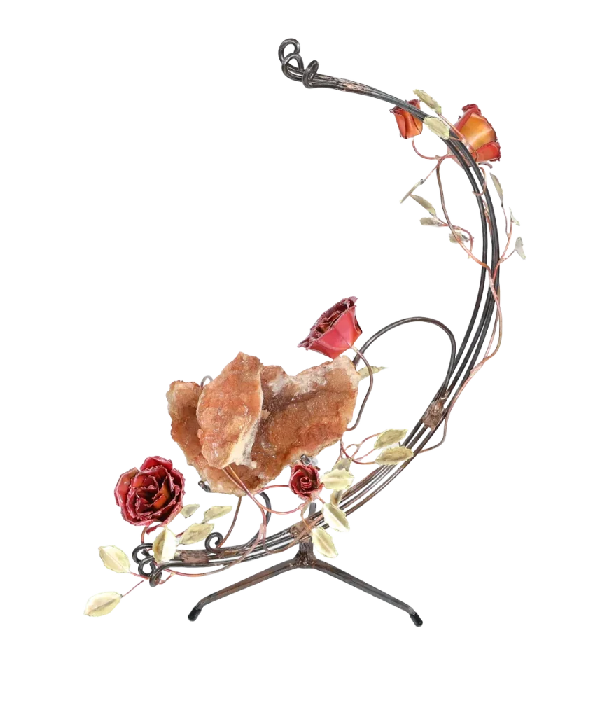 A handcrafted metal sculpture featuring a large open quartz geode nestled in the center. The open geode is supported in a semi-circular steel structure. Several copper roses and brass leaves embellish the structure, which has a metal base for stability.