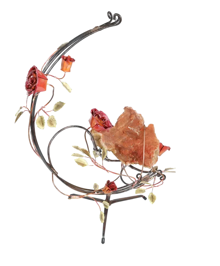 A handcrafted metal sculpture featuring a large open quartz geode nestled in the center. The open geode is supported in a semi-circular steel structure. Several copper roses and brass leaves embellish the structure, which has a metal base for stability.