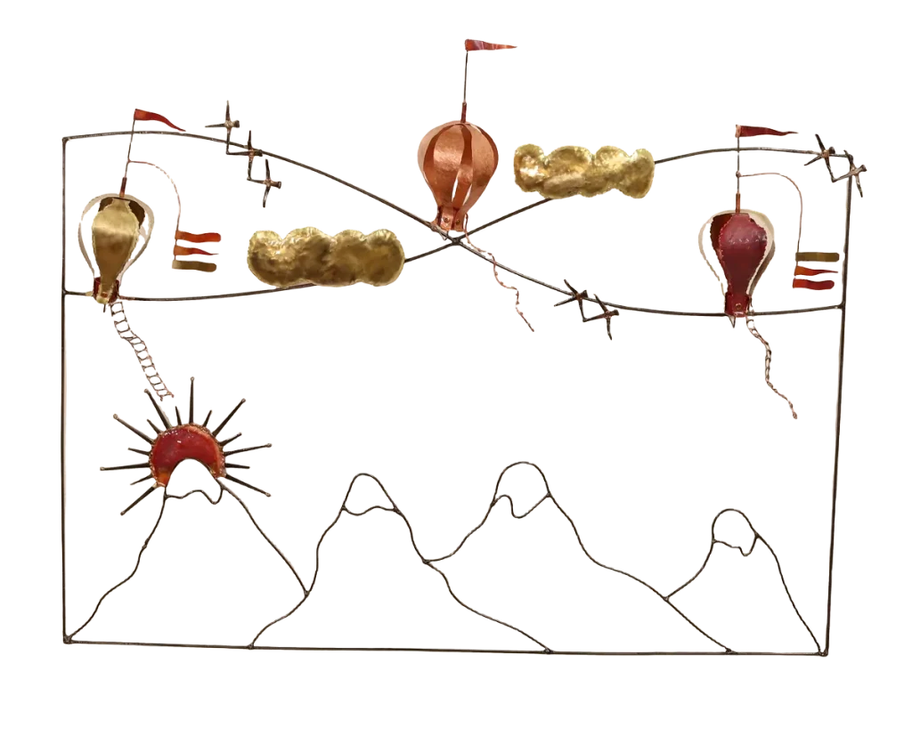 Wall mounted metal art depicting three copper and brass hot air balloons with flags, floating above stylized brass clouds and snow-capped steel mountains, with a copper sun rising over the peaks.