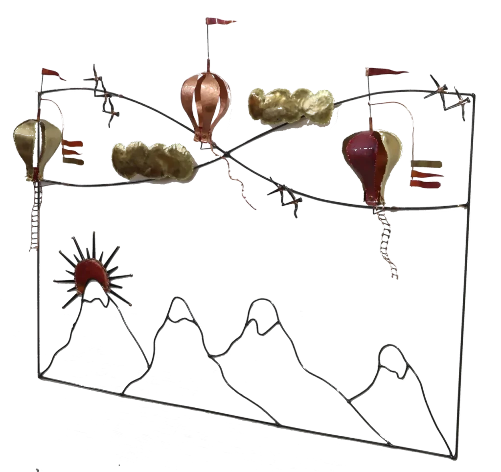 Wall mounted metal art depicting three copper and brass hot air balloons with flags, floating above stylized brass clouds and snow-capped steel mountains, with a copper sun rising over the peaks.