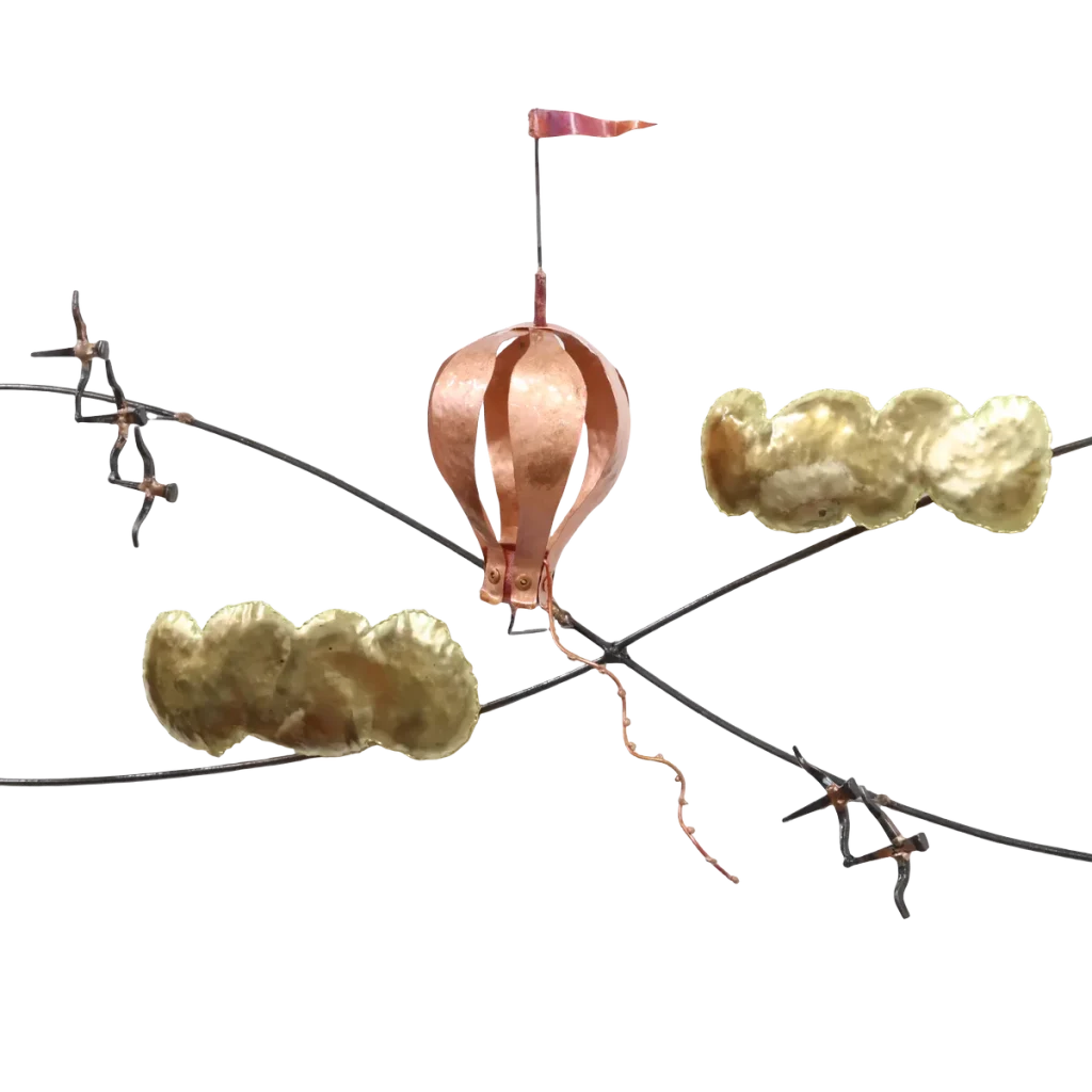 Wall mounted metal art depicting three copper and brass hot air balloons with flags, floating above stylized brass clouds and snow-capped steel mountains, with a copper sun rising over the peaks.