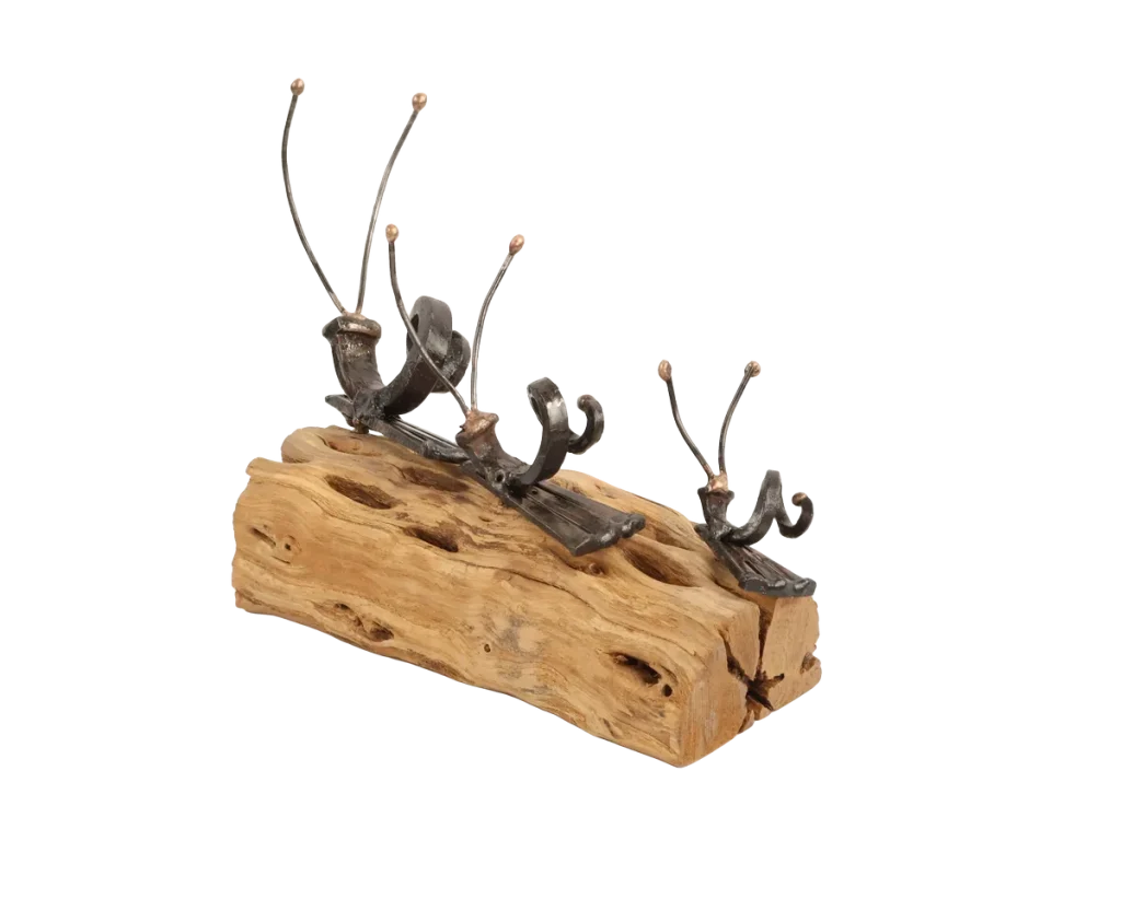 Freestanding snail metal sculpture on a piece of cholla cactus limb, featuring three different size snails with spiraled steel cut nail shells and thin steel antennae with bronze tips.