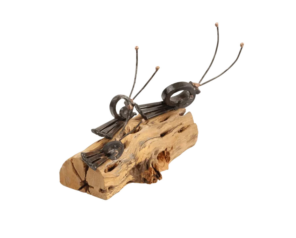 Freestanding snail metal sculpture on a piece of cholla cactus limb, featuring three different size snails with spiraled steel cut nail shells and thin steel antennae with bronze tips.