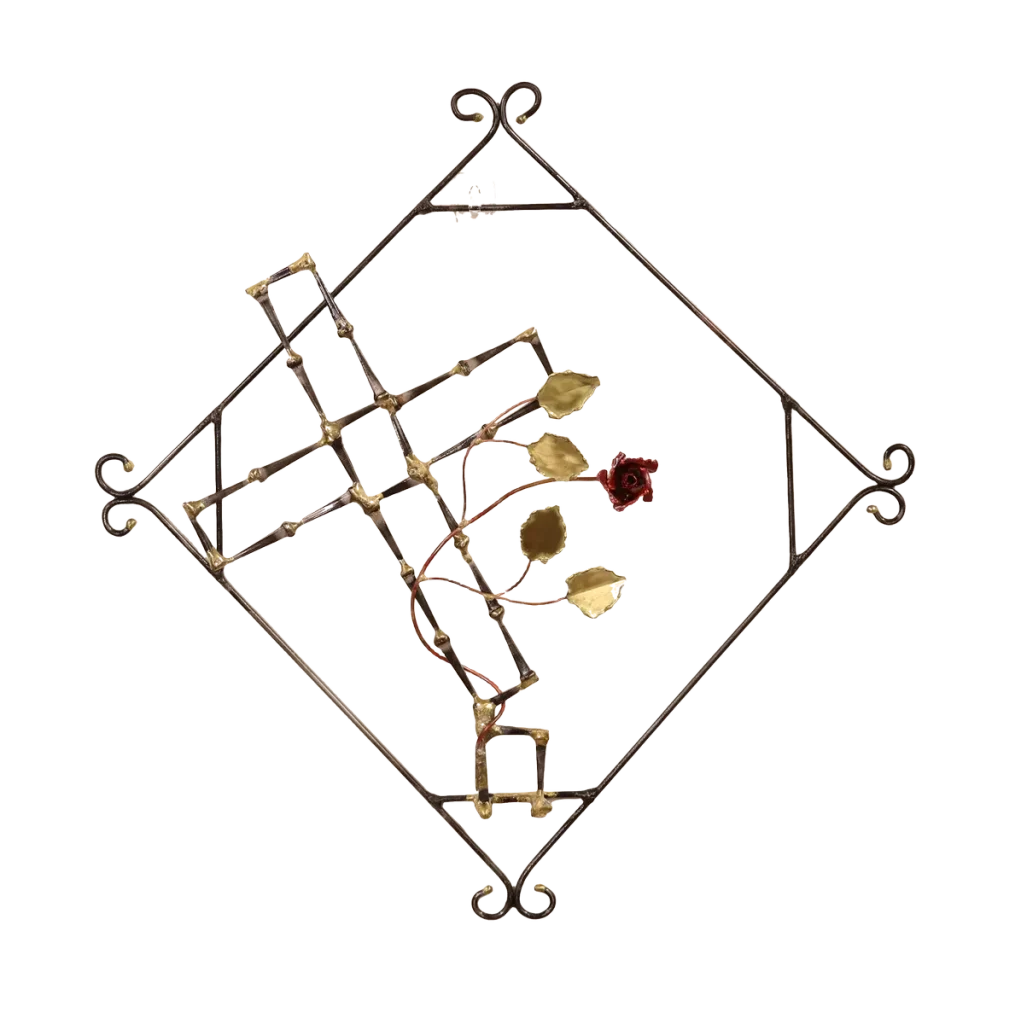 Handmade metal wall art depicting a broken cross made of steel cut nails with a copper rose and vine with brass leaves, growing out of the break in the cross. The broken cross is framed in a steel diamond shape with decorative curls. The broken cross and rose are symbolic of the resurrection of Jesus after crucifixion.